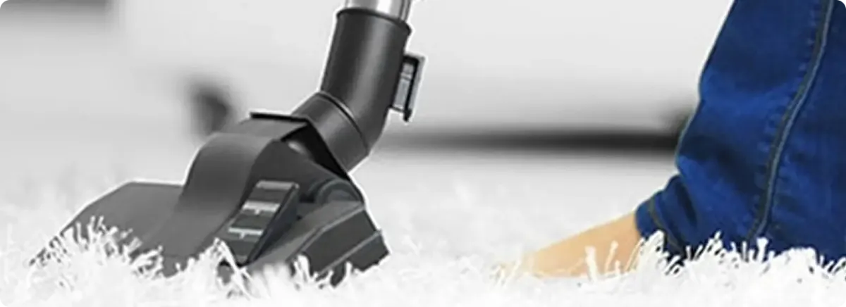 Close-up of a professional vacuuming a white carpet in Olathe.